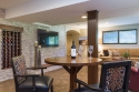 The stone wall draws the eye and is an ideal backdrop for viewing from the intimate table and chair when sharing a glass of wine or from the sectional seating seen on the right side.