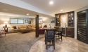 The tile-carpet border separates wet bar from seating area, as does the dark wood that is predominant in the bar area. The client's personal photos adorn the walls in the in the seating area.