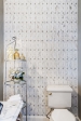 Yes, even bathrooms deserve a feature wall. This wall is a glass and marble mosaic accompanied with the small shelving and new accessories as the space's finishing touch.