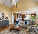 The hardwood floor was refinished from an orange-brown color. The new chandelier is an eye-catcher, and the new area rug and marble-top console on the left offer light neutrality.