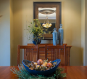 With the warmer color palette, the accessories on the table and drawers bring contrasting cool blues, greens, and grey to make the room pop.