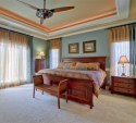 We used the existing furniture to determine a new, cooler wall color. We also added the ceiling fan and the luxurious draperies that play off the cool/neutral wall color.