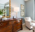 We added the lounge chair and ottoman, as well as the draperies. Combined with the brown dresser, blue-grey walls, and the wall art/accessories, it's a very cozy part of the space.