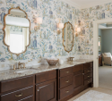 Cabinets and overhead lighting made the previous vanity crowded and dark. We removed the cabinets and added sconce lighting, new mirrors, and a new countertop with marble backsplash.