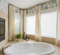The new draperies in the tub surround are an invitation for relaxation, particularly when the fireplace on the left is lit.